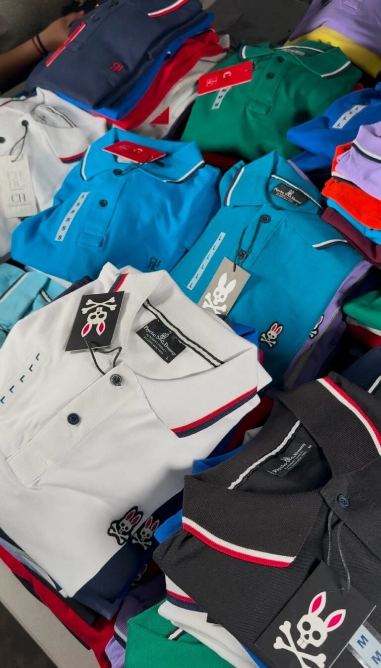 Playeras tipo polo de colores apiladas en un lote surtido