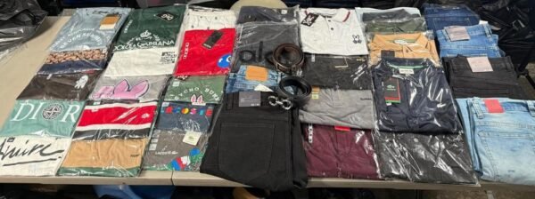 Prendas surtidas de la SuperPaca Mega sobre dos mesas: playeras de cuello redondo, playeras tipo polo, jeans, shorts y cintos